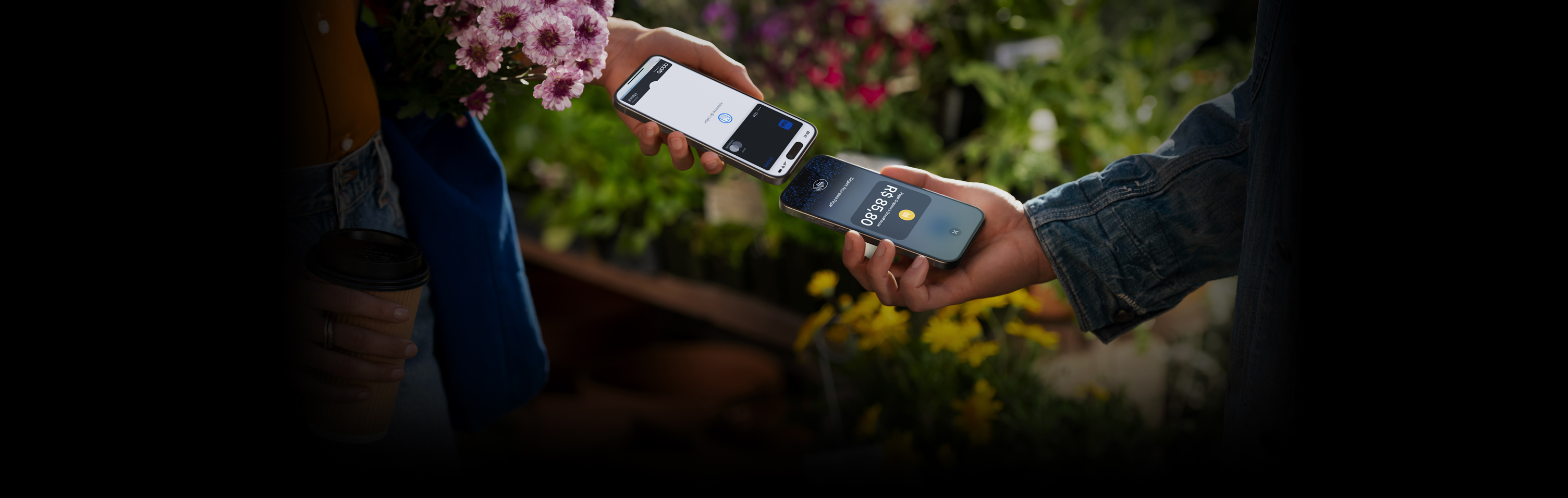 Imagem de duas pessoas segurando um iPhone próximo do outro para concluir uma transa??o.