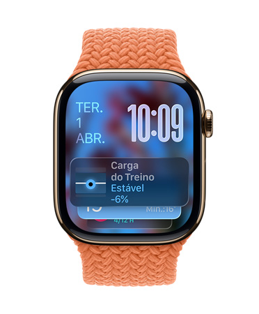 Apple Watch com caixa dourada de titanio e pulseira tran?ada tangerina, o mostrador exibe a data no canto superior esquerdo, a hora com os números organizados no canto superior direito, o widget Carga de Exercício na parte inferior, tudo em Liquid Glass translúcido