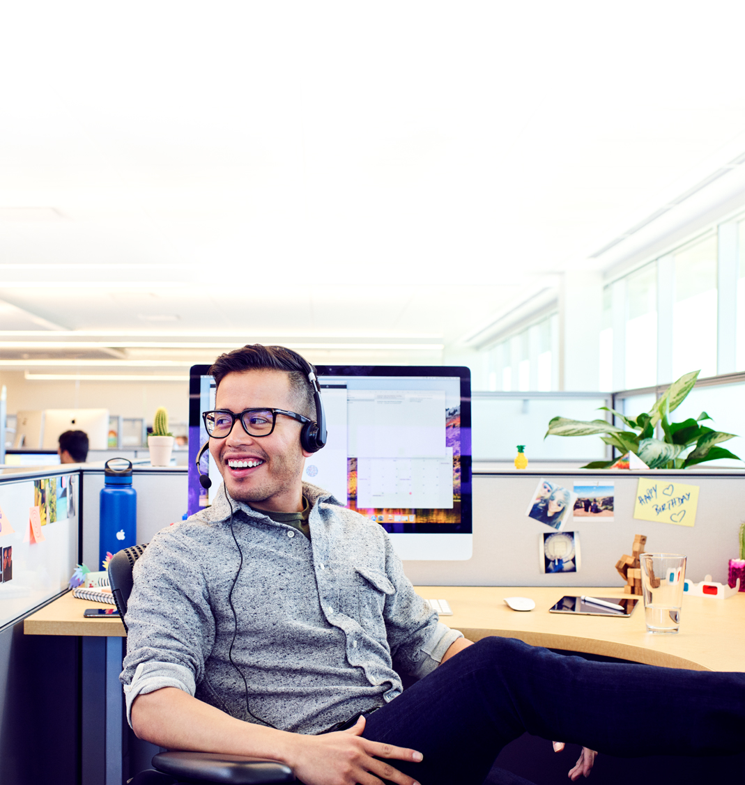 Un Apple?Support Advisor se détend entre deux appels dans son bureau, sur le campus?Apple.