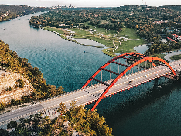 Flyfoto av en bro over en elv i Austin i Texas, med byen i bakgrunnen.