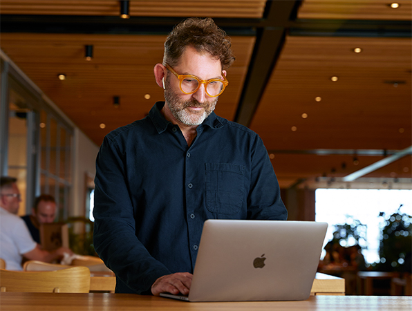 En ansatt p? Apples team for konsernfunksjoner bruker en MacBook p? Caffè Macs.