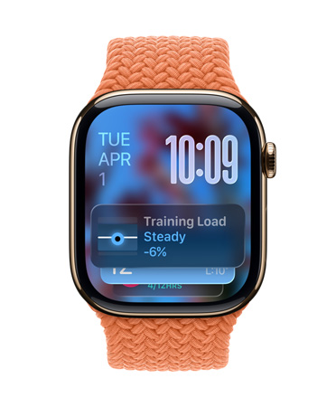 金色鈦金屬 Apple Watch 配上柑橘色編織錶帶，錶面的左上角顯示日期，右上角是以數(shù)字疊放方式顯示的時(shí)間，下方則是訓(xùn)練負(fù)荷量小工具，全以半透明的 Liquid Glass 設(shè)計(jì)呈現(xiàn)