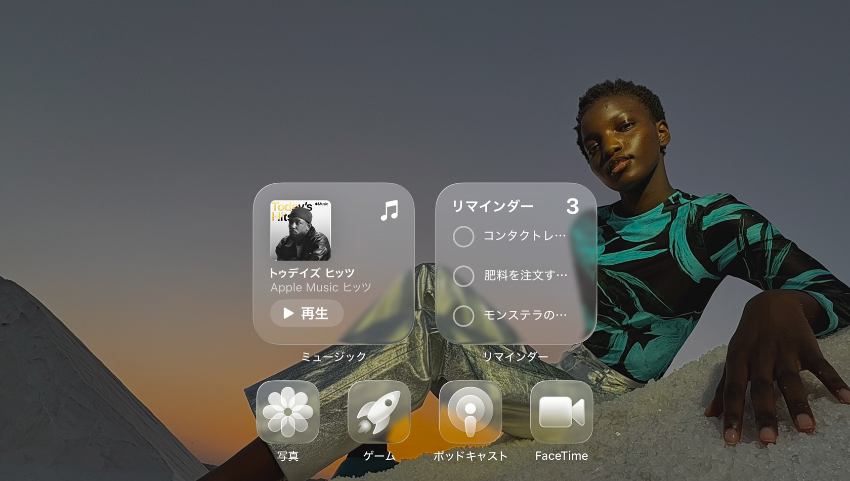 Apple Music、リマインダー、寫真、ゲーム、Podcast、FaceTimeのクリアなアプリアイコンを表示したLiquid Glassのディスプレイ。屈折された壁紙が見(jiàn)えている