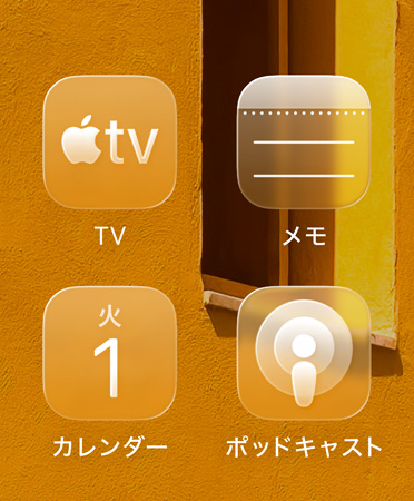 Apple TV、メモ、カレンダー、ポッドキャスト。4つの半透明なアプリのアイコンがグリッド表示され、屈折された背景が見えている
