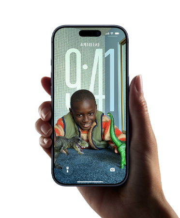 手に持ったiPhoneデバイス。ロック畫面上の畫像に合わせて時(shí)刻の表示を動(dòng)的に変化させる新しいLiquid Glassのデザインが映し出されている