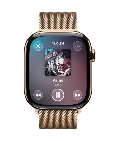 ミラネーゼループバンドを組み合わせたゴールドチタニウムのApple Watch。畫面には再生中のApple Musicと、半透明なLiquid Glassのコントロールが表示されている