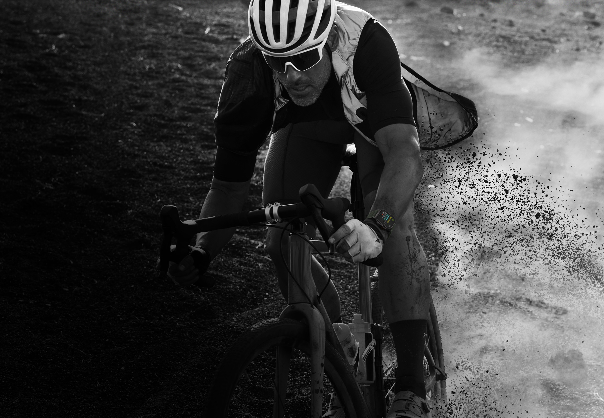 Una persona que lleva puesto un Apple Watch Ultra 2 desciende en bicicleta por un sendero de monta?a.