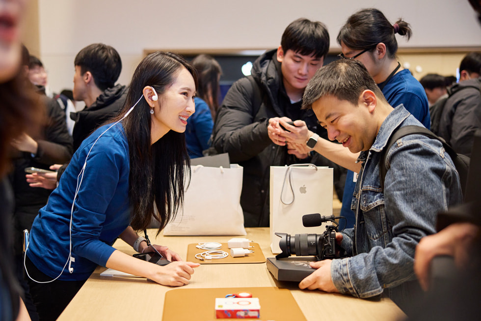Nhan viên Apple ?ang h??ng d?n khách hàng mua hàng. 