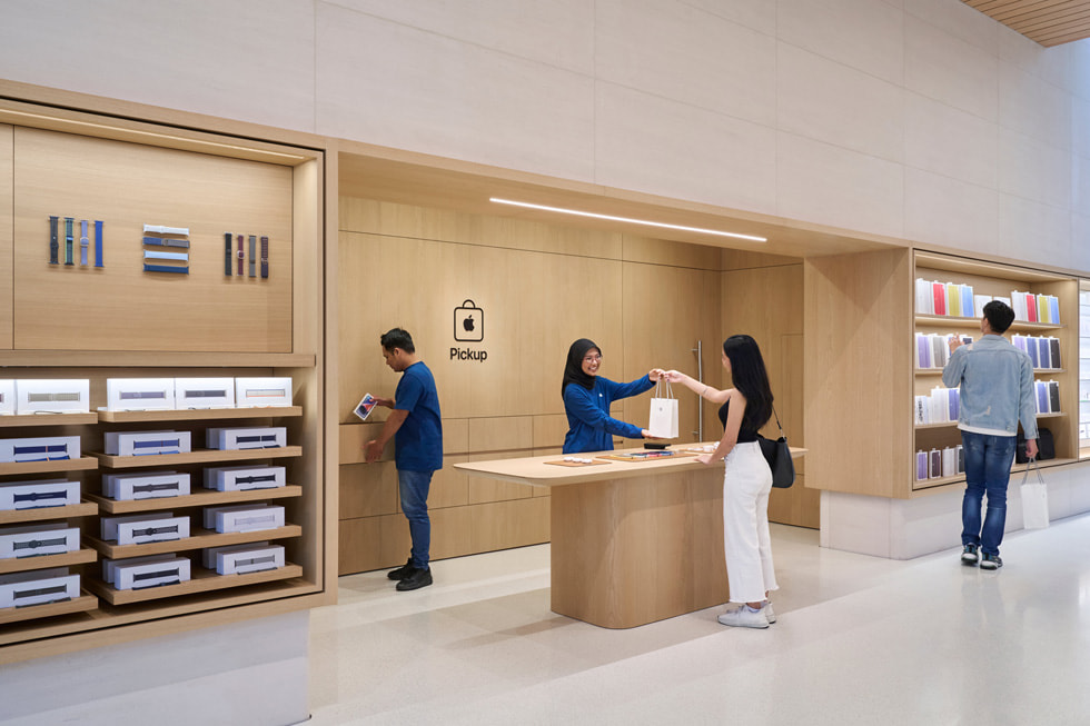 Hai nhan viên ?ang h? tr? khách hàng t?i khu v?c Apple Pickup bên trong Apple The Exchange TRX. 