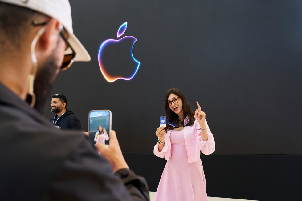 Bir Apple ekip üyesi, WWDC24 yaka kart?yla poz veren bir kat?l?mc?n?n foto?raf?n? ?ekiyor. 