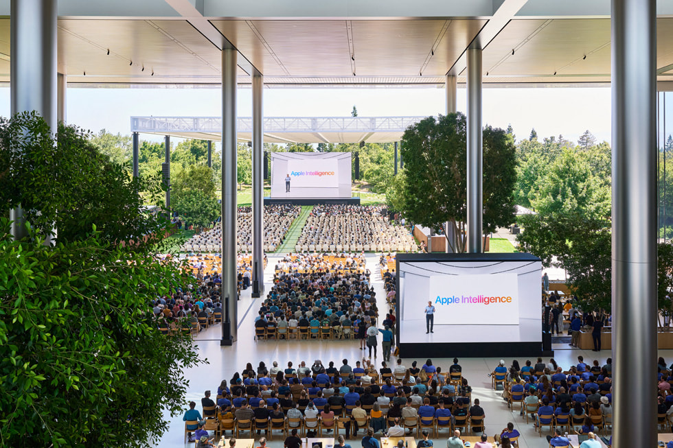 Apple Park’ta Caffè Macs’teki büyük ekranlarda Keynote sunumunu izleyen geli?tiricilerin üstten ?ekilmi? g?rüntüsü. 
