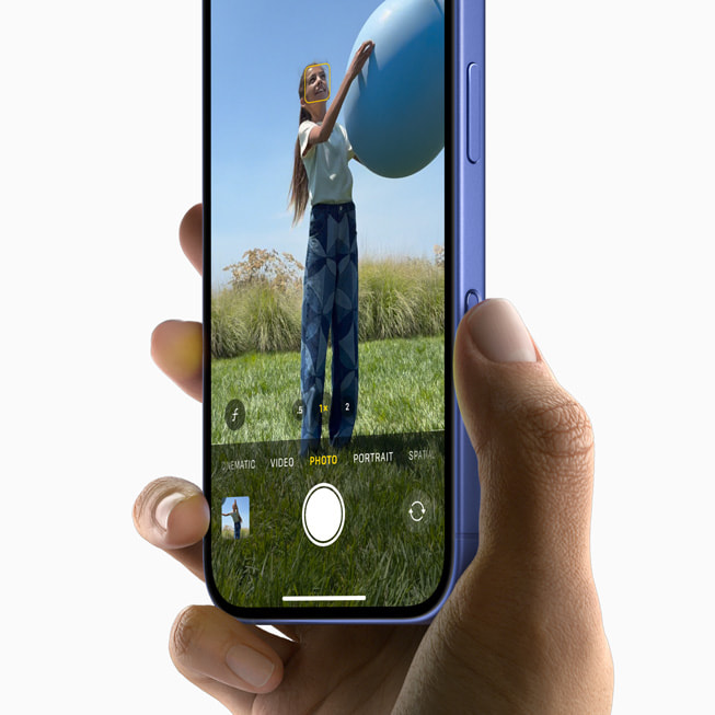Bir kullan?c? iPhone 16 ile bir top tutan ki?inin foto?raf?n? ?ekiyor.