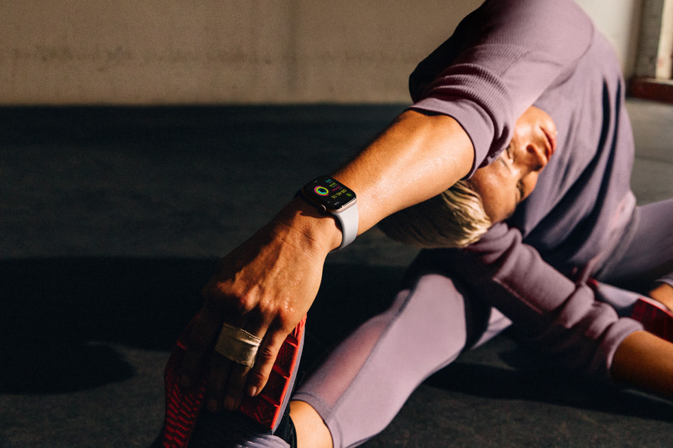 Seseorang yang mengenakan Apple Watch Series 10 melakukan peregangan dengan pose seperti yoga.
