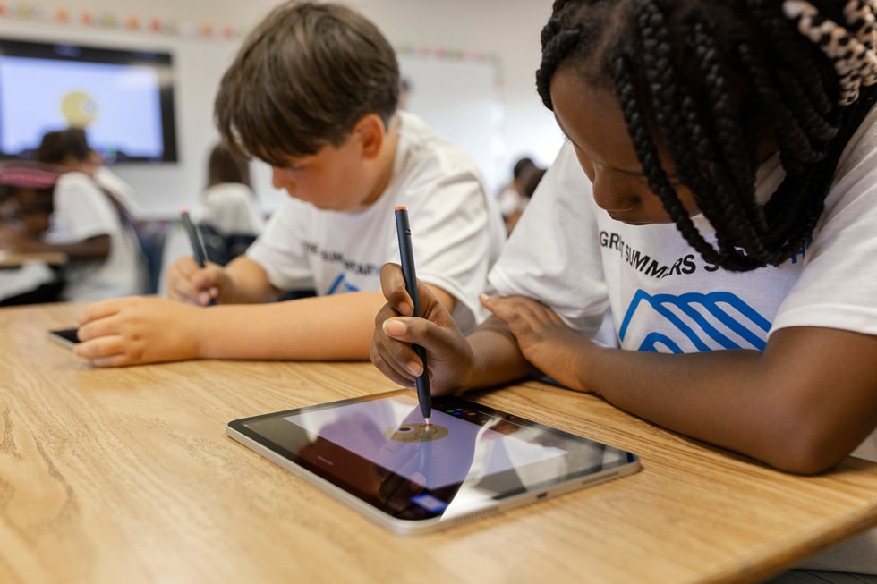 Bir ??renci, Boys & Girls Clubs of America personeliyle birlikte iPad’de kod yazma al??t?rmas? yap?yor.