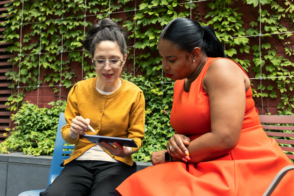 New York Halk Kütüphanesi üyelerinden Evelyn von Gizycki elinde bir iPad ve Apple Pencil tutarak, NYPL’den Dr. Brandy McNeil ile birlikte d??ar?da oturuyor.
