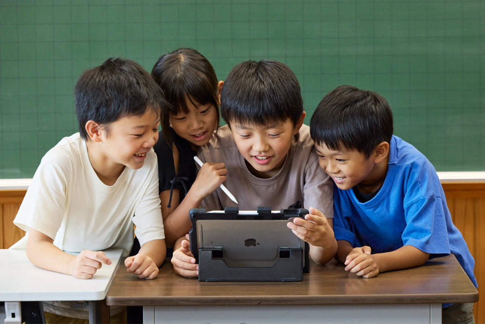 京都市の小學(xué)校の教室で、iPadとタッチペンを使って作業(yè)している4人の子ども。