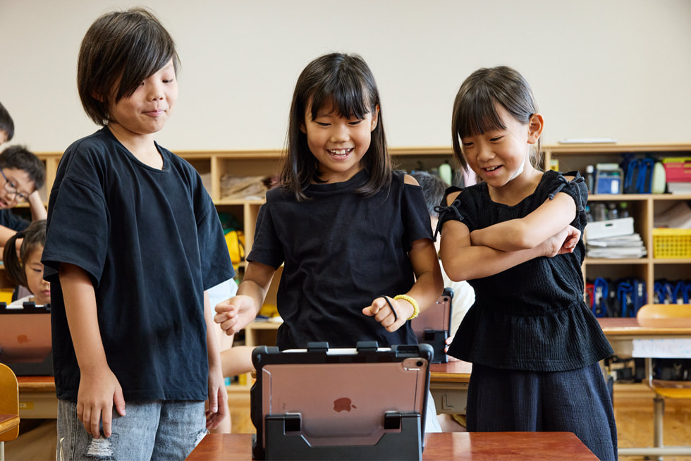 京都の小學(xué)校の教室で、iPadを見ている3人の子ども。