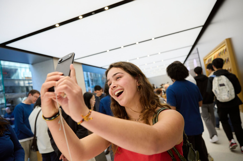 澳洲 Apple Sydney 零售店內，一位顧客開心地手持 iPhone Air 自拍。