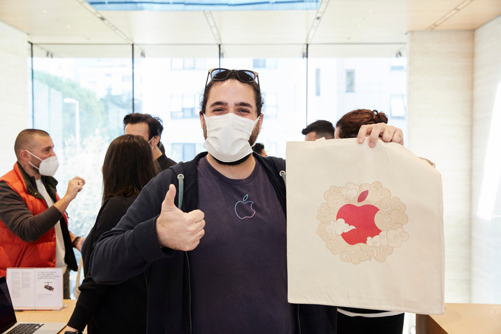Apple ti??rtlü bir adam elindeki Apple logosunu g?stererek ba? parma??yla ?ok iyi i?areti yap?yor.
