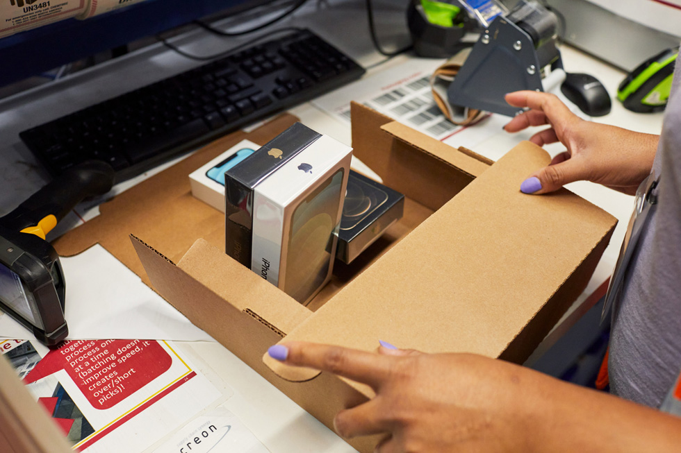 An Apple distribution centre employee packs a shipment of iPhone 12 and iPhone 12 Pro. 