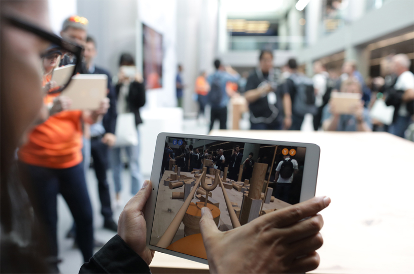 Bir iPad kullan?c?s? ekranda AR deneyimiyle SwiftShot oynuyor.