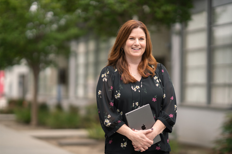 Downey Unified’?n ilkokullardan sorumlu e?itim direkt?rü ve Apple Learning Coach olan Jennifer Robbins, d?? mekanda bir iPad tutarak ayakta duruyor.