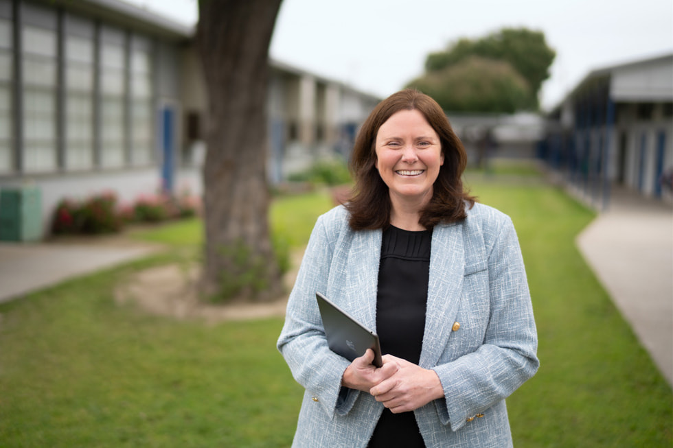 Downey, California’da Lewis Elemantary School müdürü Allison Box, d?? mekanda bir iPad tutarak ayakta duruyor.