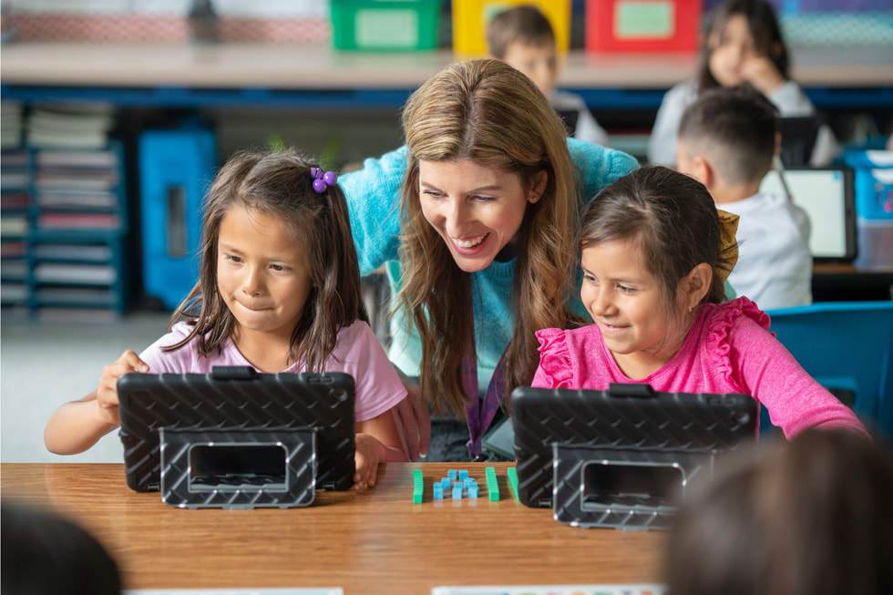 Downey Unified School District ??retmenlerinden Lindsay Barnes, s?n?fta iki birinci s?n?f ??rencisiyle iPad kullanarak ?al???yor.