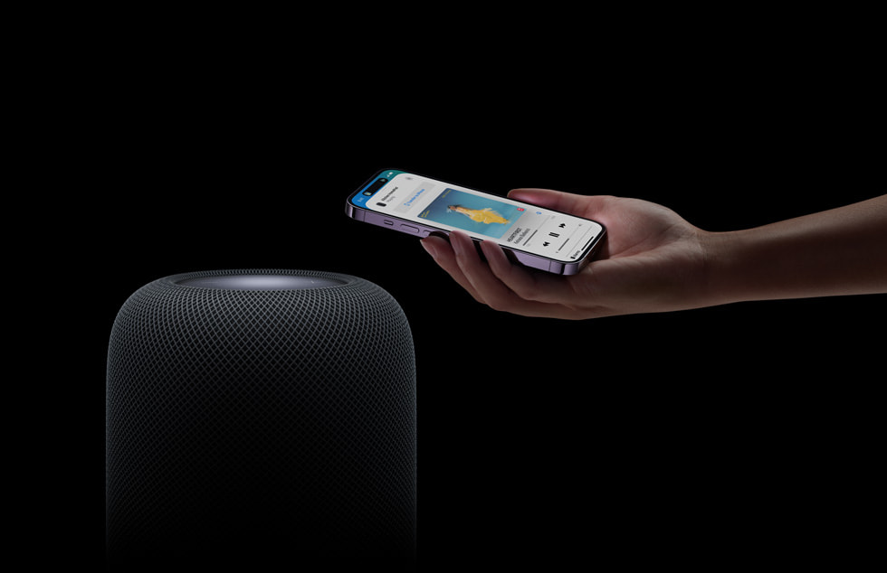 HomePod’un (2. nesil) üzerinde elinde iPhone tutan bir kullan?c?.