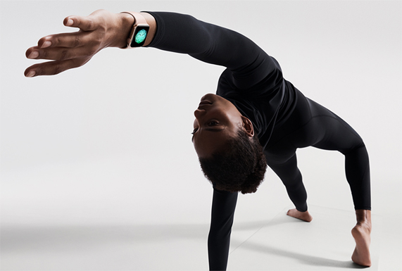 Alt?n renkli iPhone Watch Series 4 giymi? bir kad?n mat üzerinde bir yoga duru?unda.