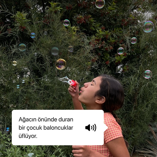 A?ac?n ?nünde duran bir ?ocuk baloncuklar üflüyor.