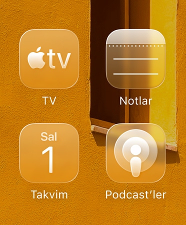 Apple TV uygulamas?, Notlar, Takvim ve Podcast’ler olmak üzere d?rt yar? saydam uygulama simgesinden olu?an ?zgara arka plan? yans?t?yor