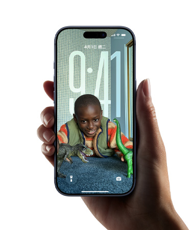 一隻手拿著 iPhone 裝置，展示全新 Liquid Glass 設(shè)計(jì)，讓時(shí)間顯示隨鎖定畫(huà)面上的影像動(dòng)態(tài)調(diào)整