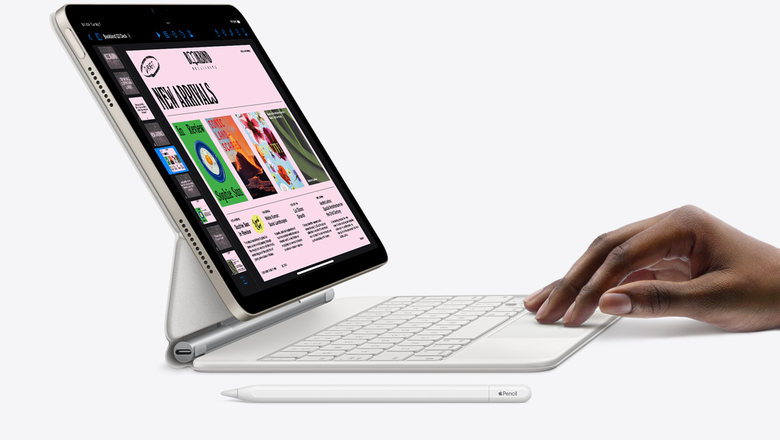 Vue latérale d’un iPad Air montrant l’app Keynote, fixé à un Magic Keyboard avec une main posée sur le trackpad et un Apple Pencil posé à c?té.