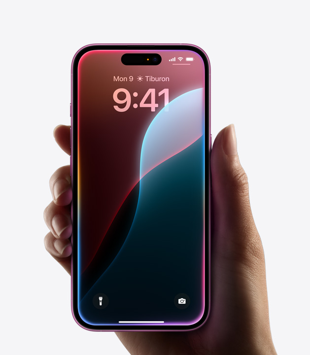 一隻手握著邊緣發(fā)出彩色光芒的 iPhone 16。