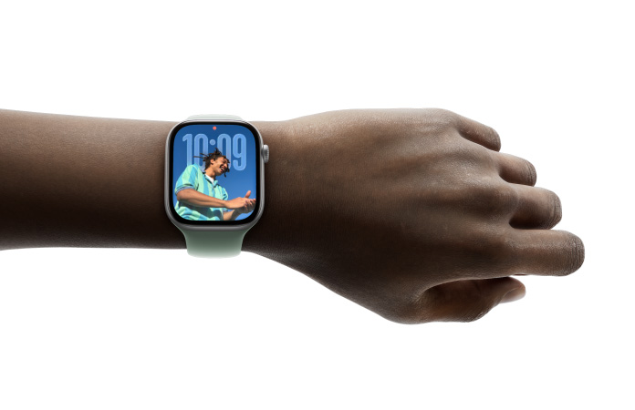 Apple Watch in Silver with rubber band on a person's wrist, face shows notes app and a message